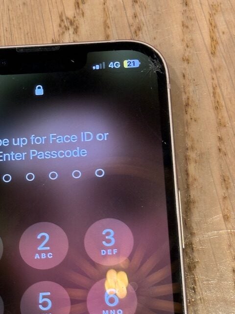 Close-up showing crack on iPhone 13 display before repair at Costa Coffee Richmond Station TW9