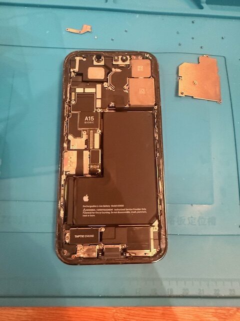 Inside view of iPhone 13 Pro with A15 chip exposed during water-damage treatment