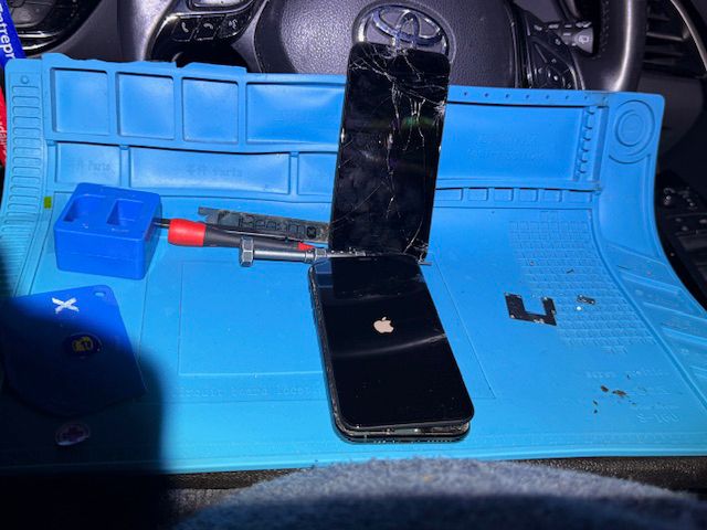 Technician attaching new screen to iPhone