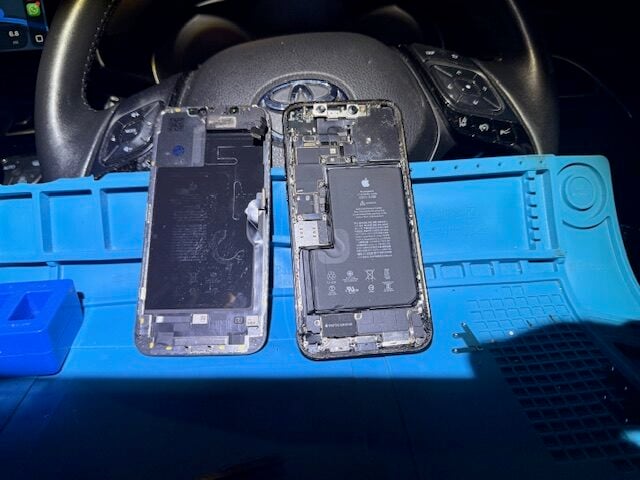 iPhone 12 Pro Max screen removed with internal components visible during repair