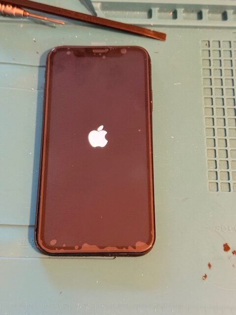 Technician performing final iPhone adjustments