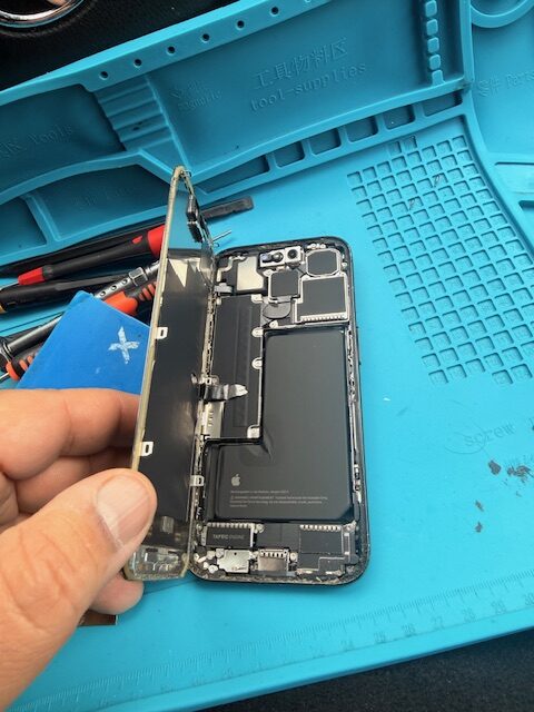 Opening iPhone 15 Pro screen using pentalobe screwdriver during mobile repair service in Paddington Green W2 London