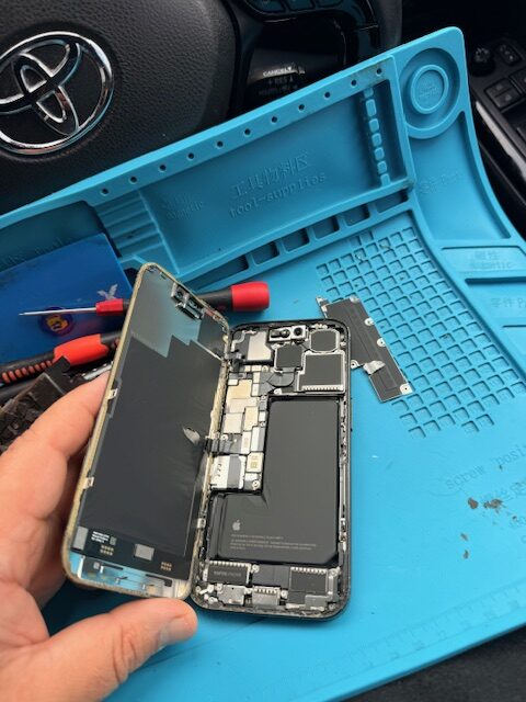 Removing internal metal shield and disconnecting display connectors during iPhone 15 Pro screen repair in London W2