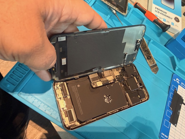Step 5 iPhone 15 Pro Max screen replacement process with display lifted for connector access