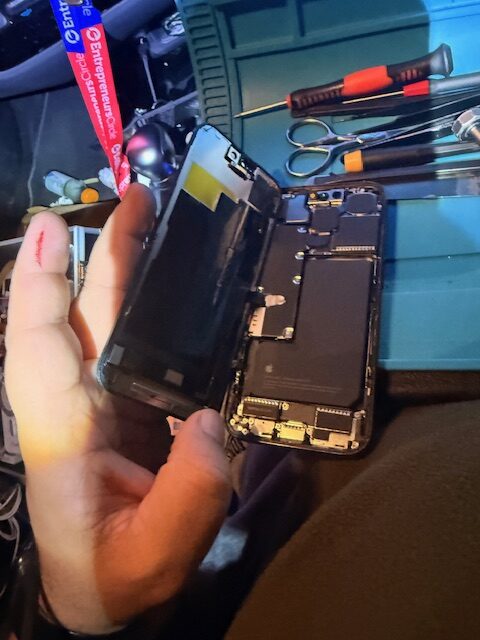 Attaching new iPhone 15 Pro display to logic board during mobile screen repair in Paddington Green W2 London