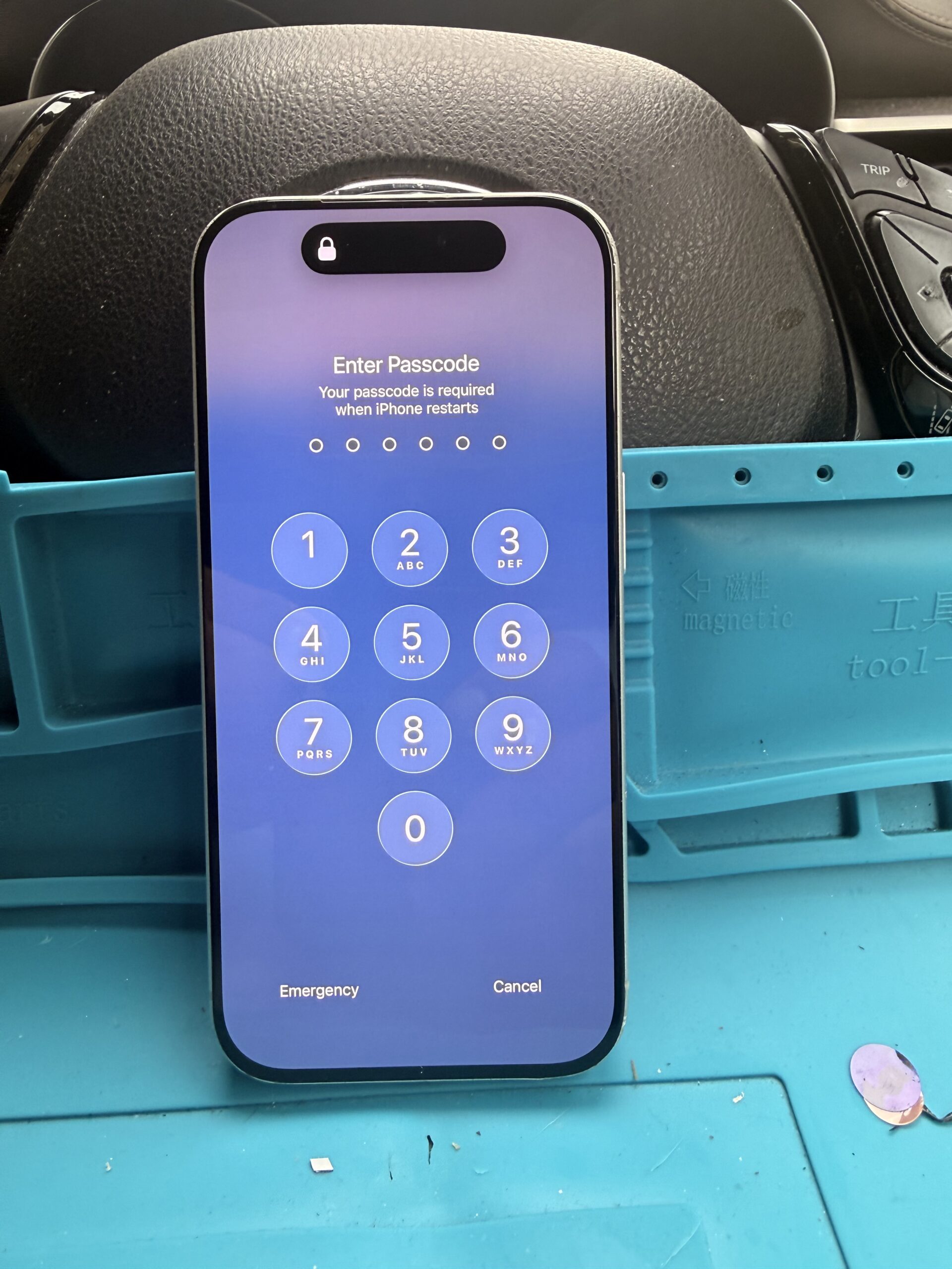 Reassembled iPhone 17 Pro with intact replacement glass displaying the passcode keypad after restarting.